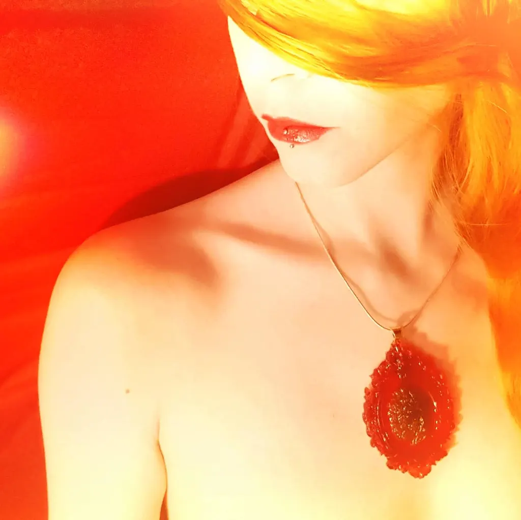 A red resin pendant, worn